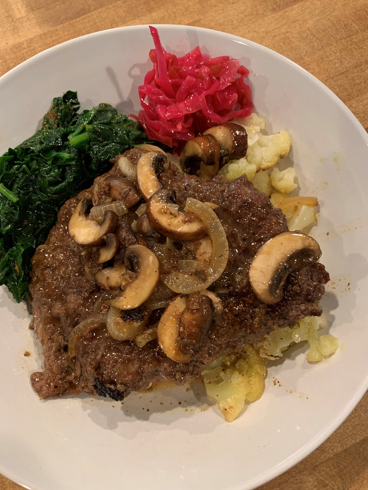 cooked grassfed cube steak with mushroom, saurekraut and spinach
