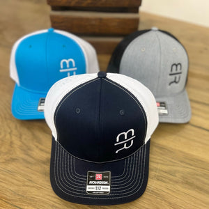 
                  
                    Navy blue trucker hat with white stitching and white MR brand on the crown.  
                  
                