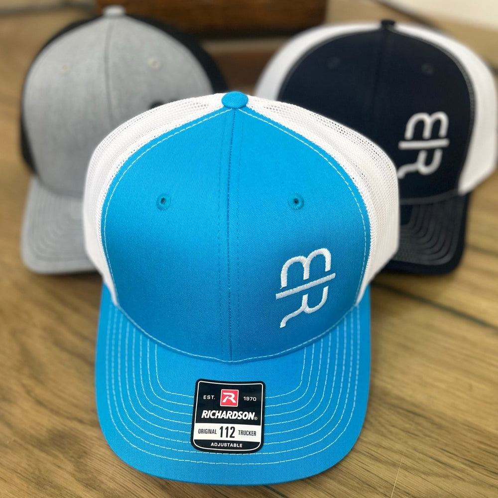 
                  
                    Teal colored snapback trucker hat with MR brand
                  
                