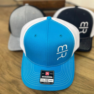 
                  
                    Teal snapback trucker hat with white MR brand
                  
                